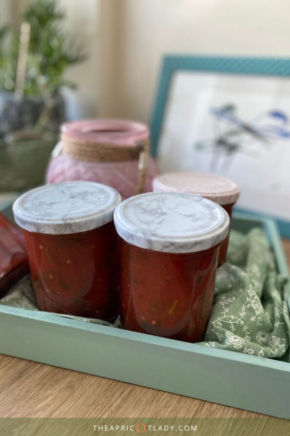 Eingekochte Tomatensauce in Gläsern auf Tablett